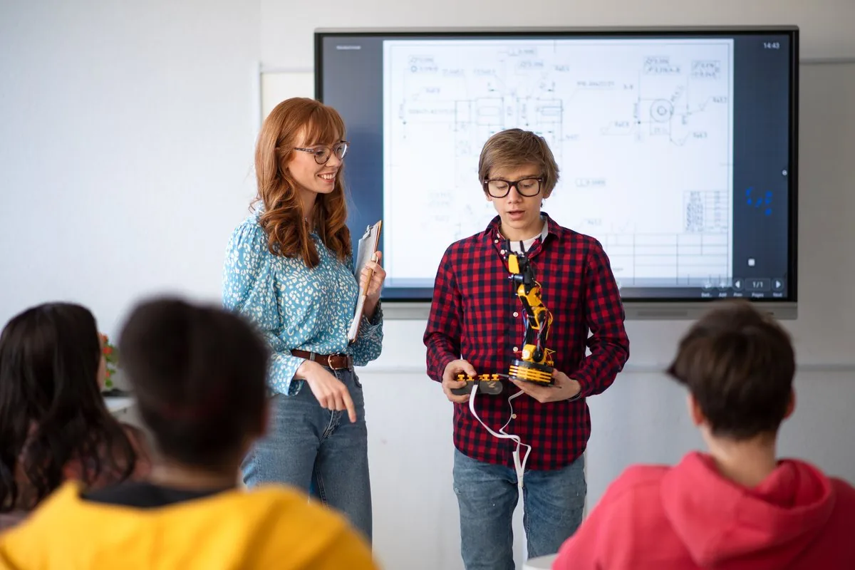 Dos estudiantes exponiendo su proyecto ante la clase